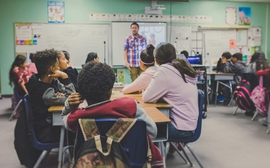 Teacher guiding young students at their desks